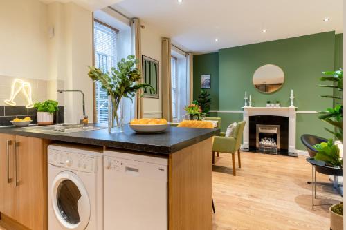 切尔滕纳姆Regency Basement Apartment的厨房以及带洗衣机和烘干机的客厅。