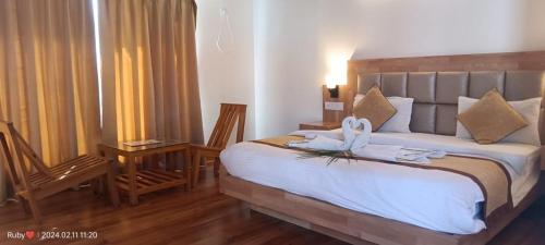 BelparāoJim Corbett Tiger Resort的一间卧室配有一张大床和毛巾