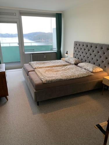 巴特塞格贝格Panoramablick über den See的一间卧室设有一张大床和大窗户