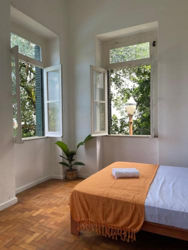 里约热内卢Castelo dos Tucanos Hostel的一间卧室设有2扇窗户和1张床铺