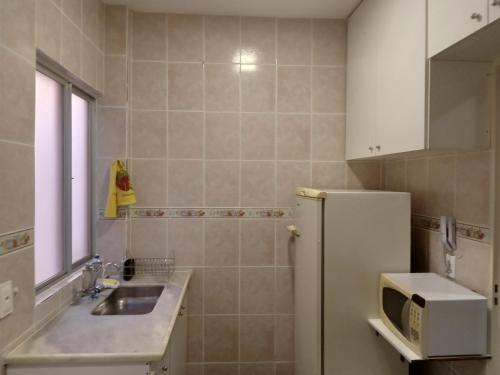贝洛奥里藏特Apartamento encantador的厨房配有水槽和冰箱