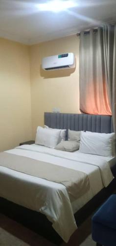JiruBenji Apartments的卧室配有一张大白色床和窗户
