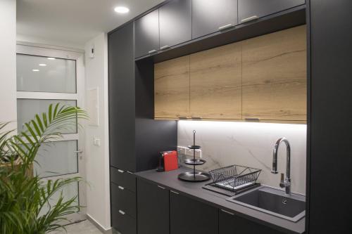 尼科西亚STAY Urban Skin Suite的厨房配有黑色橱柜和水槽