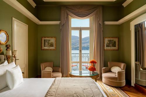 特雷梅佐特雷麦梭大酒店的一间卧室设有一张床、一个窗口和一张桌子