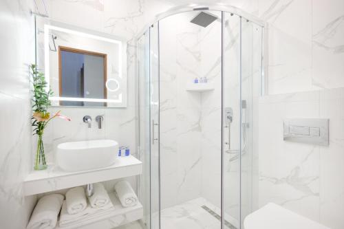 依诺罗达林德罗斯酒店的带淋浴和盥洗盆的白色浴室