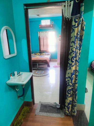 普里jharana guest house的一间带水槽和镜子的浴室以及一间客房