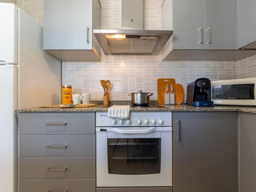 利乌玛Holiday Home Gaviota 13 by Interhome的厨房配有白色橱柜和炉灶烤箱。