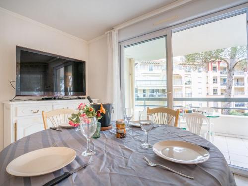 圣艾格夫Apartment Le Grand Parc-6 by Interhome的一间带桌子和大窗户的用餐室