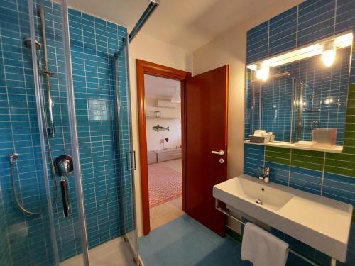 卡波利韦里Lido I Palmizi的浴室设有水槽和蓝色瓷砖淋浴。