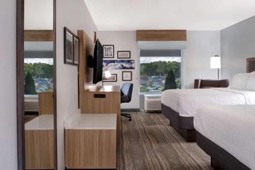 伊斯利汉普顿伊斯利酒店的酒店客房配有一张床和一张书桌及一台电视