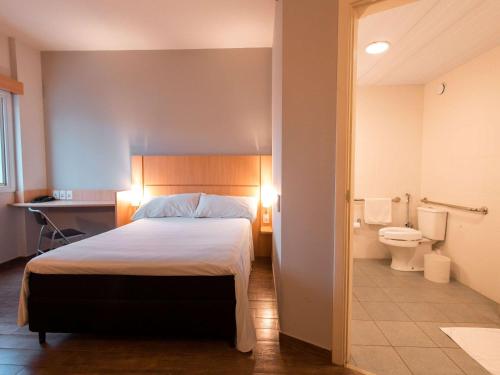 普鲁登特总统城ibis Presidente Prudente Manoel Goulart的一间卧室配有一张床,浴室设有卫生间