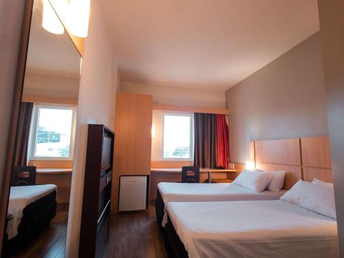 普鲁登特总统城ibis Presidente Prudente Manoel Goulart的酒店客房设有两张床和电视。