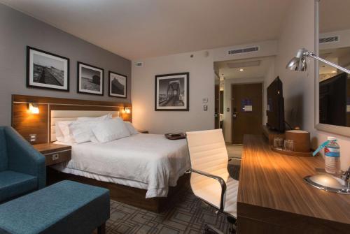 埃莫西约希尔顿埃莫西约汉普顿酒店的酒店客房设有床和客厅。