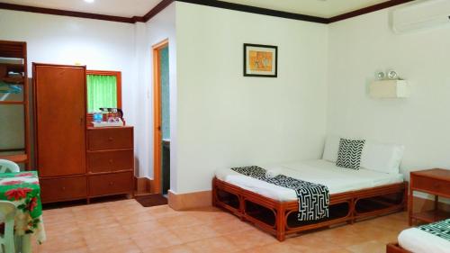 罗昂HMC Guesthouse - Malapascua Island Air-conditioned Room #2的一间位于客房角落的带一张小床的房间