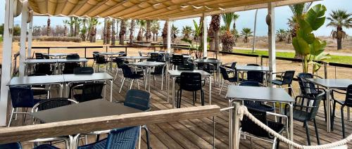 格拉德卡斯特利翁Pensión La Ola的木甲板上设有桌椅的餐厅