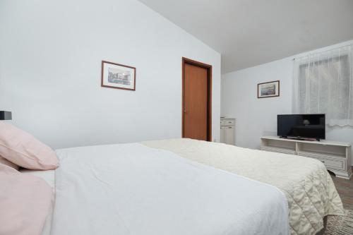 波雷奇St. Bečić的一间白色卧室,配有床和电视