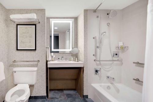 范尔Highline Vail - a DoubleTree by Hilton的浴室配有卫生间、盥洗盆和浴缸。