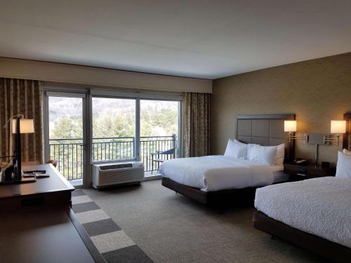 布恩北卡州布恩汉普顿酒店及套房的酒店客房设有两张床和一个阳台。