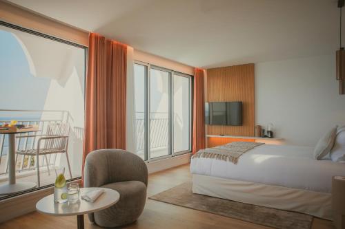 拉格朗德默特Hôtel La Plage 5 étoiles La Grande Motte的酒店客房设有一张床和一个阳台。