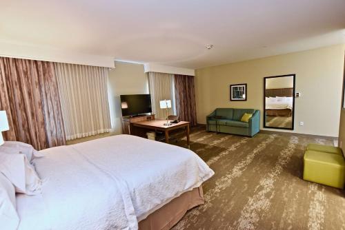 柯克斯维尔Hampton Inn By Hilton Kirksville MO的酒店客房设有一张大床和一张沙发。