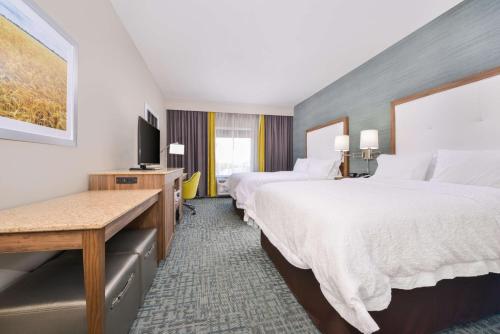 恩波里亚Hampton Inn Emporia, KS的酒店客房设有两张床和一台平面电视。