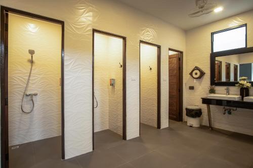 奥南海滩Sea Beach Hostel & Club AoNang Beachfront的一间带4个淋浴间和盥洗盆的浴室