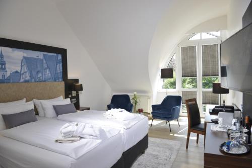 策勒卡罗琳玛蒂尔德酒店的一间卧室配有一张床、椅子和一张书桌