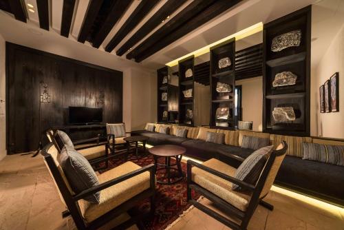 Al Khuţaym阿丽拉贾巴尔阿赫达度假村的客厅配有沙发、椅子和电视