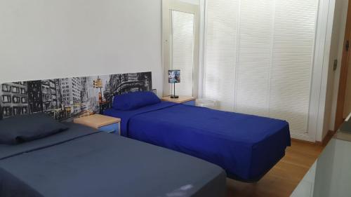 莫斯托雷斯Casa Pinares的卧室设有两张床铺,配有蓝色床单