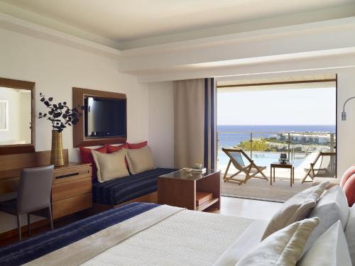 伊罗达Porto Elounda Golf & Spa Resort, Six Senses Spa的酒店客房设有一张床,享有海景。
