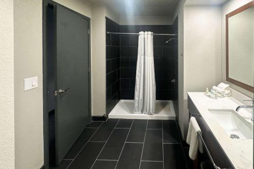 波特兰Quality Inn Portland Airport PDX的带浴缸、淋浴和盥洗盆的浴室