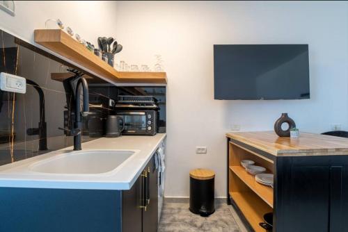 海法eve's room的一个带水槽的厨房和墙上的电视