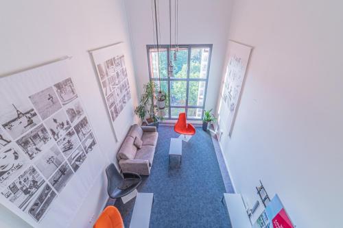 里昂Residence Montempo Lyon Cite Internationale的带沙发和红色椅子的客厅