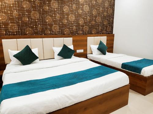 戈勒克布尔HOTEL JVS PALACE的蓝色和白色的酒店客房内的两张床