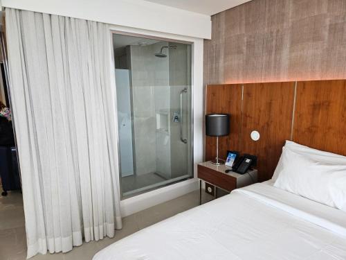 里约热内卢Hotel Nacional的一间卧室设有一张床和一个玻璃淋浴间