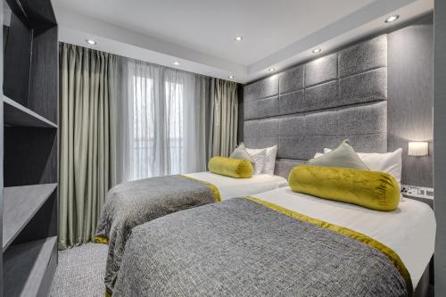 伦敦伦敦维多利亚莫宁顿酒店的酒店客房 - 带两张带黄色枕头的床