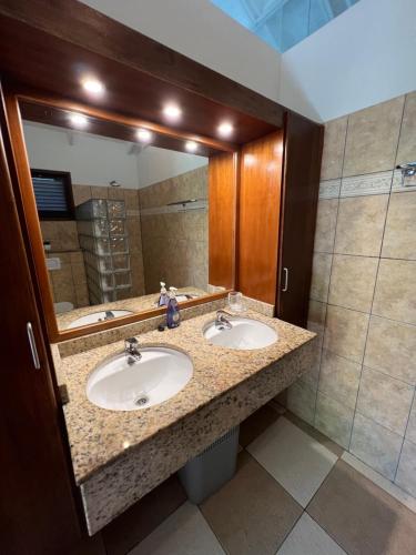 Blue BayVrijstaande BB BEACH Villa Azure的一间带两个盥洗盆和大镜子的浴室