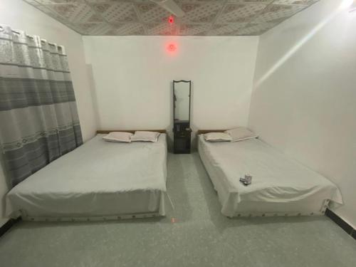 JaliapāraSurjasto Resort的红色灯小客房内的两张床
