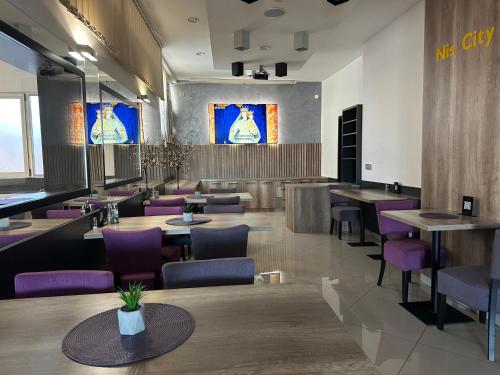 尼什Garni Hotel Niš City View的餐厅设有木桌和紫色椅子