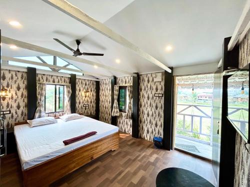 加尔各答Palli Bangla Resort, near Ruby Hospital, Anandapur的一间卧室设有一张床和一个大窗户