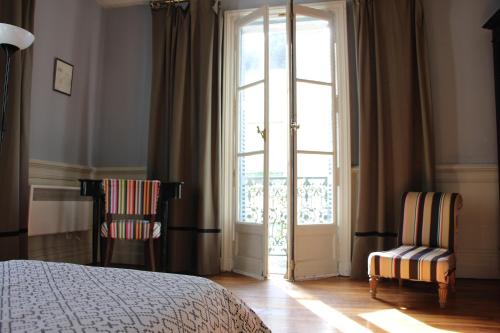 圣艾尼昂拉提拉希德塔芙度假屋的卧室配有一张床和两把椅子,位于窗户前