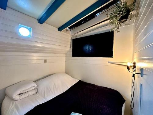 阿姆斯特丹Houseboat in Amsterdam的一个小房间的小床,设有窗户