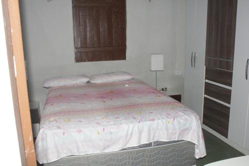 伊卡普伊Casa c WiFi a beira mar na Praia Redonda,Icapui CE的小卧室配有一张带粉红色棉被的床