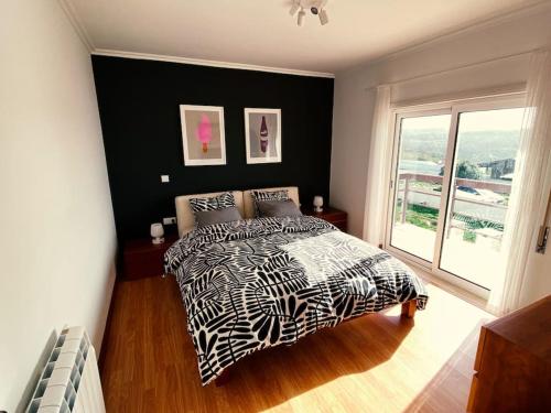 帕塔亚什Casa da Brisa do Mar的卧室设有黑白床和窗户。