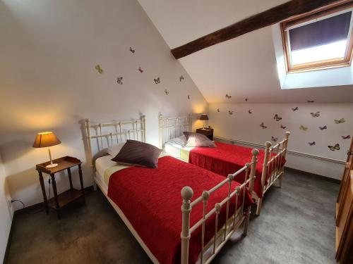 Chailly-en-GâtinaisGîte Chailly-en-Gâtinais, 5 pièces, 8 personnes - FR-1-590-7的卧室内的两张床,墙上有红色床单和蝴蝶