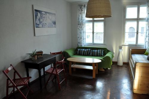 泰普拉河畔贝乔夫Apartmán u Mlsného medvěda的客厅配有绿色沙发和桌子