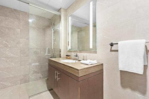 阿布扎比Silkhaus Chic 1BDR at Najmat Near Reem Central Park的浴室配有盥洗盆和带镜子的淋浴