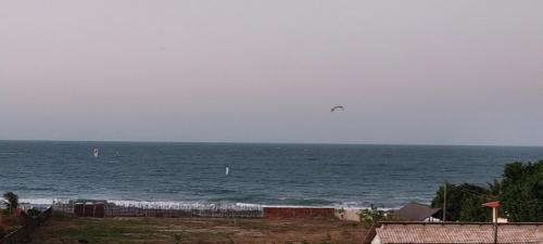 São Gonçalo do Amarantecasa na Taiba - de frente ao mar - piscina - lagoa do kite的风筝在海滩上飞越海洋