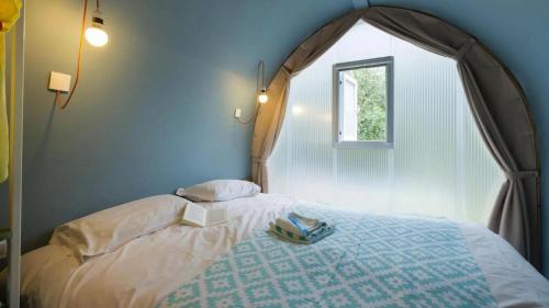 代讷坎普Papillon Country Resort的一间卧室配有一张带拱形窗户的床