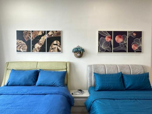 马西Cozy couple apartment suite的墙上有三张照片的房间的两张床